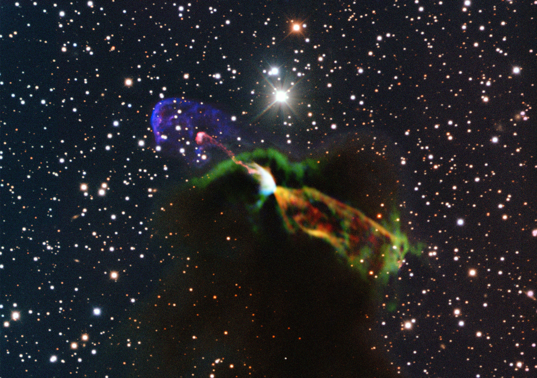 A dark cloud blocks out background stars. Infront, two jets of material shoot in opposite directions from a central object