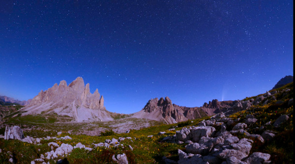 The Big Dipper drifts lower towards the horizon on the left, on the right a comet rises in the sky.