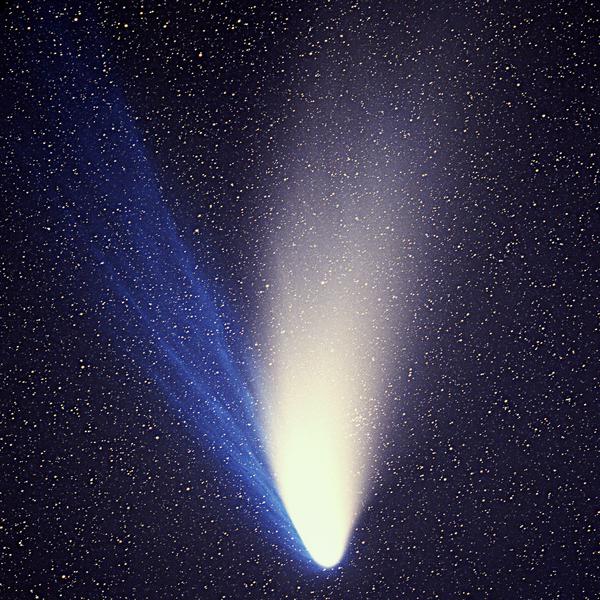 Immagine di tipica cometa con ampia coda bianca e una seconda blu, inclinata di 30° in senso antiorario rispetto alla prima.
