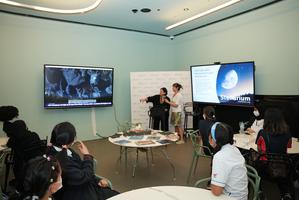 Two staff members instruct students about a classroom exercise