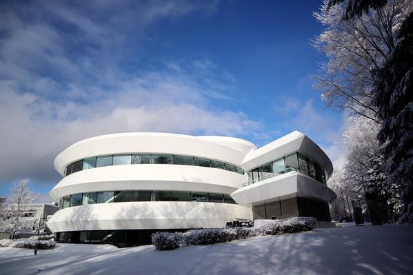 The Haus der Astronomie building. This is a white, modernist building shaped like an simplified depiction of a spiral galaxy