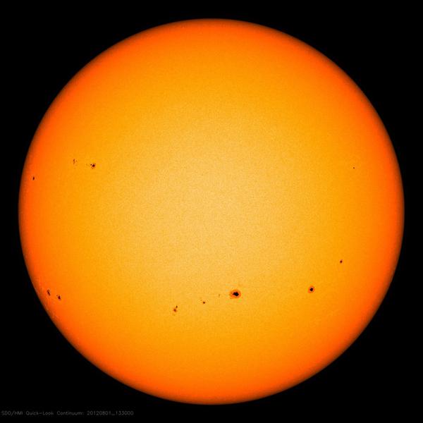 Image showing groups of sunspots as dark patches which lie in bands above and below the Sun's equator