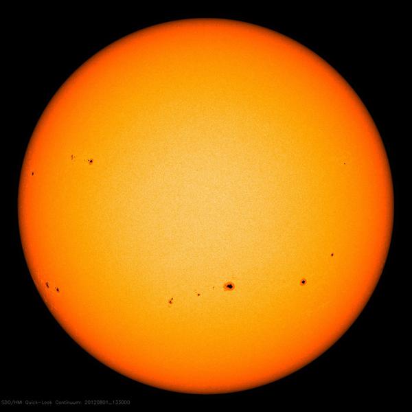 Image showing groups of sunspots as dark patches which lie in bands above and below the Sun's equator