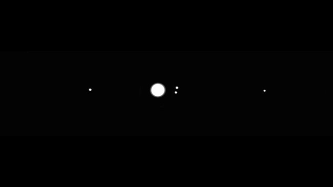 The planet Jupiter, seen here as a bright disk, is orbited by the four Galilean moons, seen here as bright dots