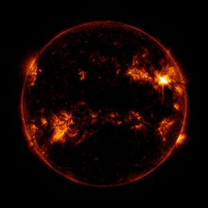 Le Soleil dans l'ultraviolet apparaît comme un cercle. L'éruption est une tache brillante en haut à droite, à 3/4 de la distance du centre.