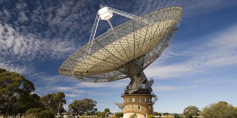 Panorama of the Parks Radio Telescope with blue sky and few thin clouds. The telescope looks like a giant satellite dish.