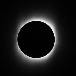 La Luna appare come un cerchio nero che blocca la luce del Sole. Un tenue bagliore dalla corona solare circonda la Luna.