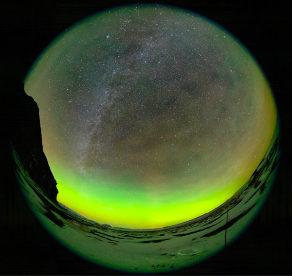 The sky rotates around one star that appears fixed. Bubbles and swirls of green aurorae fill the foreground