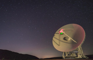 The dish of a radio telescope rotates as the Big Dipper moves in the sky behind.