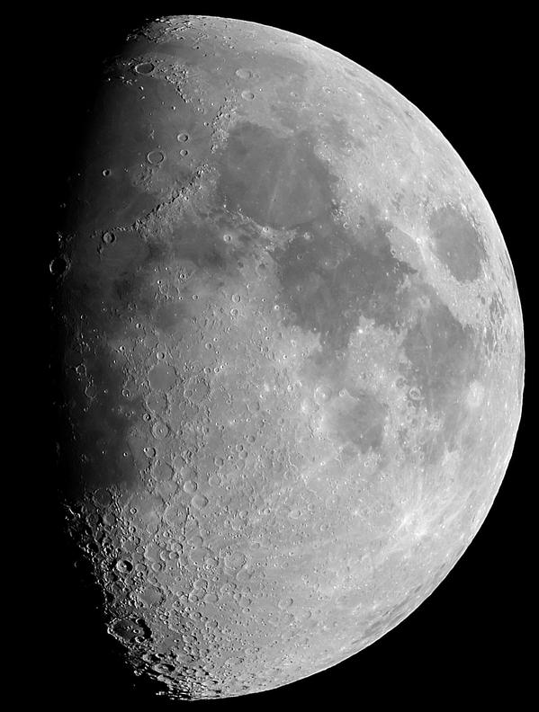 The Moon with craters, light highlands and dark plains. The left hand side of the Moon (about 2/3 of the disk) is in shadow