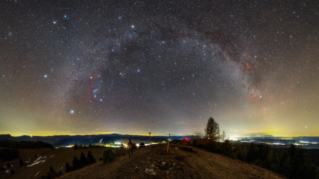 Unter dem Band der Milchstraße befinden sich der sanduhrförmige Orion und die hellen Sternhaufen der Plejaden.