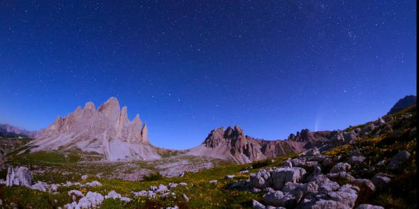 A sinistra l'Orsa Maggiore si abbassa verso l'orizzonte, a destra una cometa si staglia nel cielo.