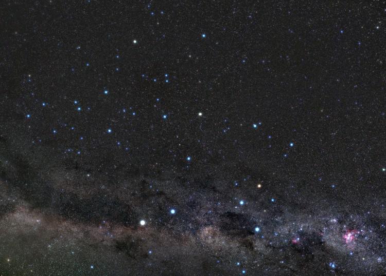 The Southern Cross forms a kite shape in front of the mottled light and dark patches of the Milky Way.