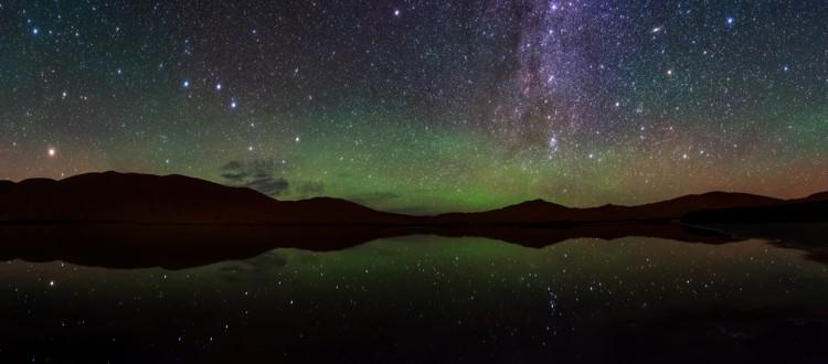 The ladle-shaped Big Dipper with the orange star Arcturus to its left. Right is the diffuse disk-shaped Andromeda galaxy