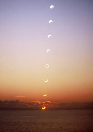 Eight images of the Sun rising. From the lower, earlier images the Moon moves across the Sun from top left to bottom right.