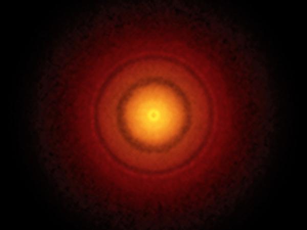 Una serie di anelli chiari e scuri che ricordano un bersaglio per il tiro con l'arco intorno alla stella TW Hydrae