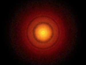 Una serie di anelli chiari e scuri che ricordano un bersaglio per il tiro con l'arco intorno alla stella TW Hydrae