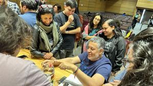 One person points at a spherical glass flask while others look on