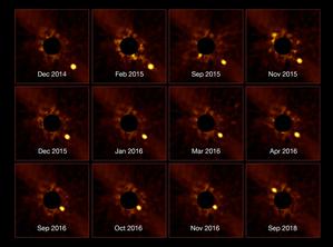 beta Pictoris b si sposta dal basso a destra verso il centro dell'immagine, riapparendo 22 mesi dopo in alto a sinistra.