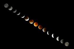 A composite of images of the Moon. Along the sequence of images, the Moon's colour changes from grey to red and back to grey.