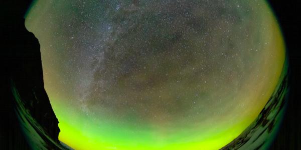 Il cielo ruota attorno a una stella che appare fissa. Bolle e vortici di aurore verdi riempiono il cielo in primo piano.