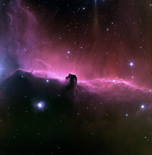 The Horsehead Nebula is a horse-shaped silhouette, surrounded by glowing gas and scattered stars.