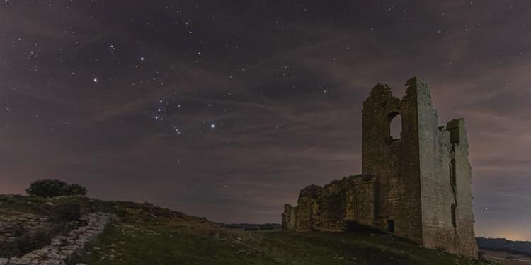 The bright stars in Orion trace a shape similar to a bow tie, here tilted by 45 degrees in-front is a ruined building