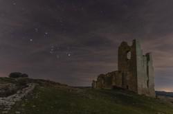 Le stelle luminose in Orione tracciano la forma di un papillon, qui inclinato di 45 di fronte a delle rovine.