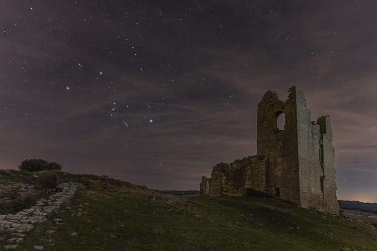 Le stelle luminose in Orione tracciano la forma di un papillon, qui inclinato di 45 di fronte a delle rovine.