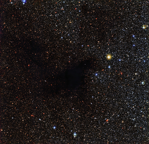 The dense interstellar dust cloud LDN 483 appears as several dark blobs against a rich background of stars.