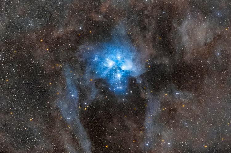 Un ammasso di stelle blu brillanti illumina il gas nebulare circostante.