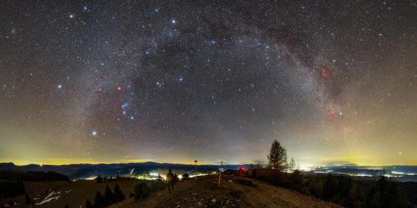 In front of the curve of the Milky Way we find the hourglass-shaped Orion and the bright Pleiades star cluster.