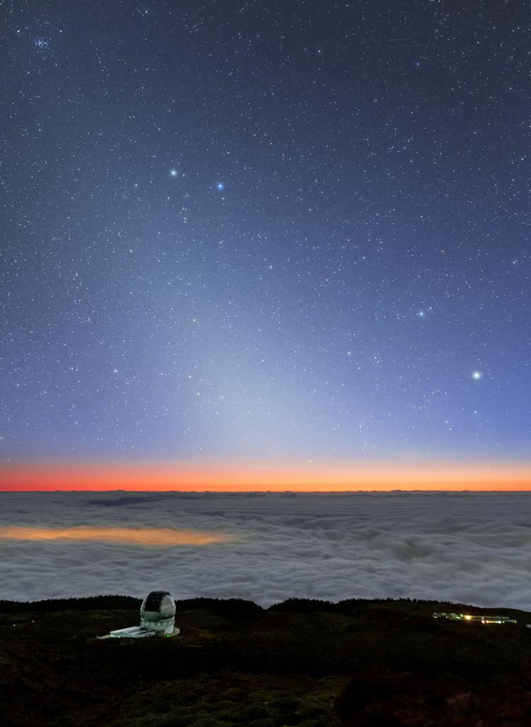 Un bagliore omogeneo e diffuso si estende dall'orizzonte verso l'alto a sinistra. In alto a sinistra due stelle luminose.